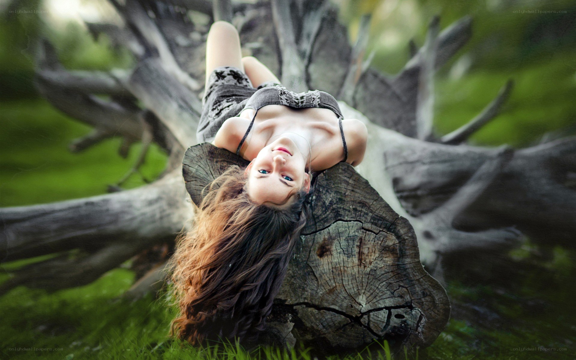 woman lying on a tree stump