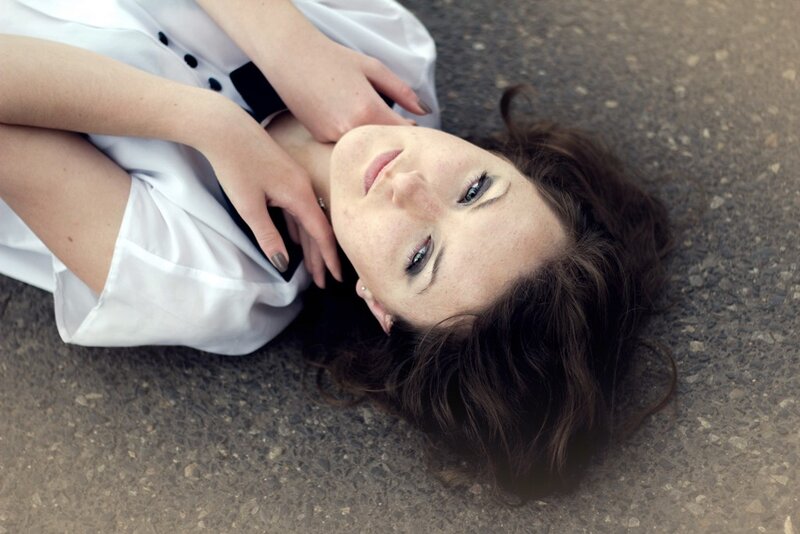 woman lying on asphalt