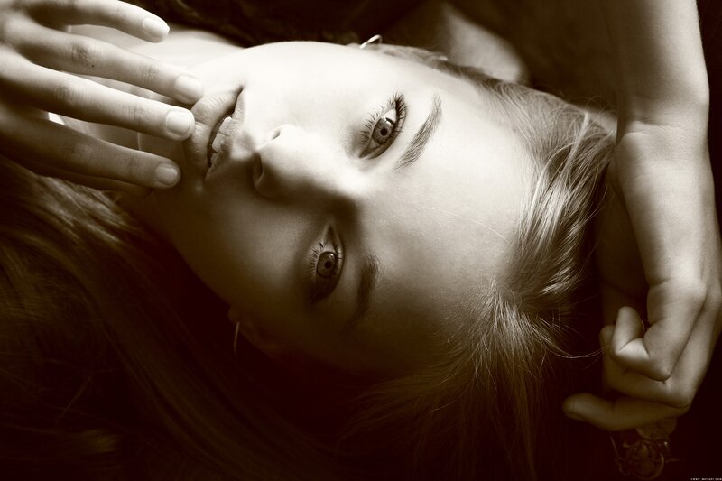 woman lying on back with hands near face