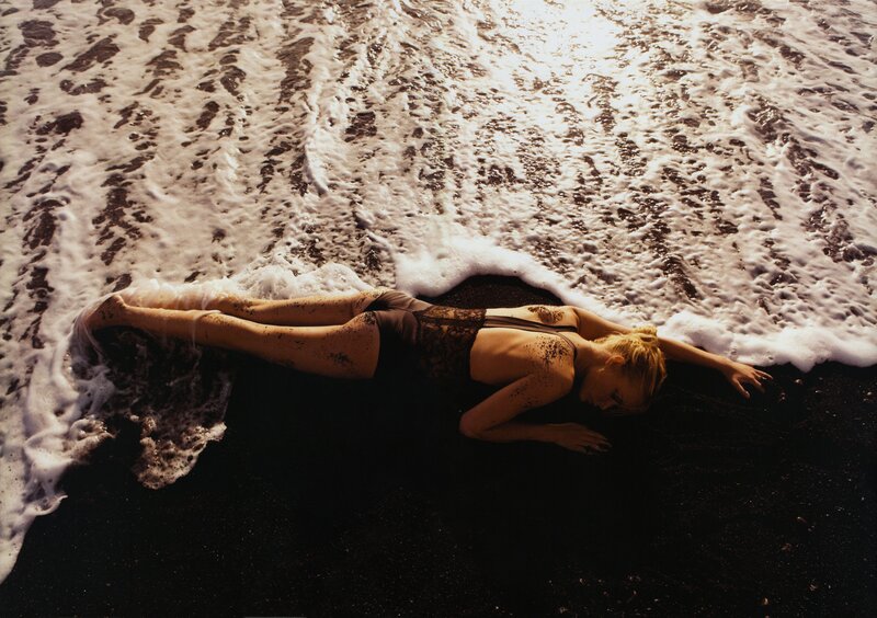 woman lying on beach at sunset