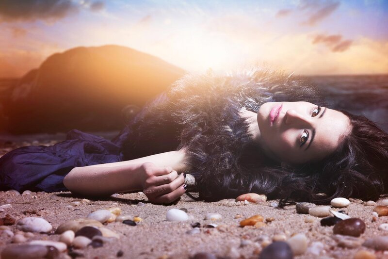 woman lying on beach at sunset