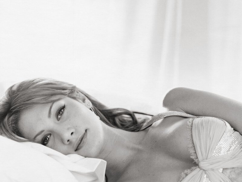 woman lying on bed in black and white