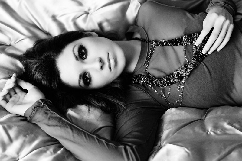 woman lying on bed in black and white
