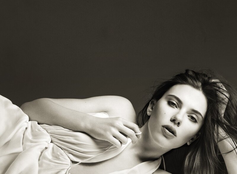 woman lying on bed in black and white