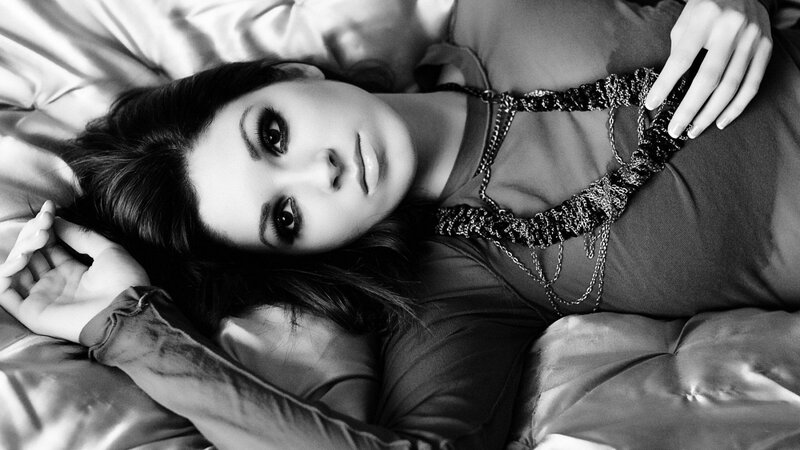 woman lying on bed in black and white