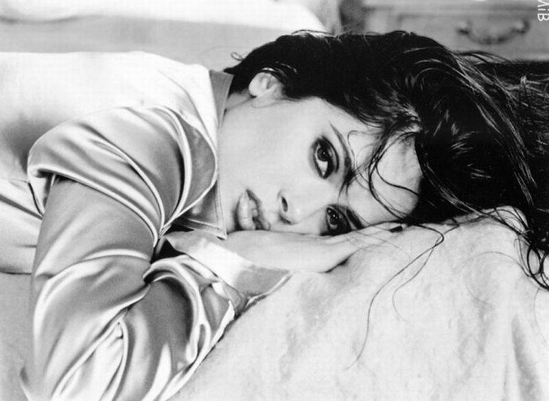 woman lying on bed in black and white