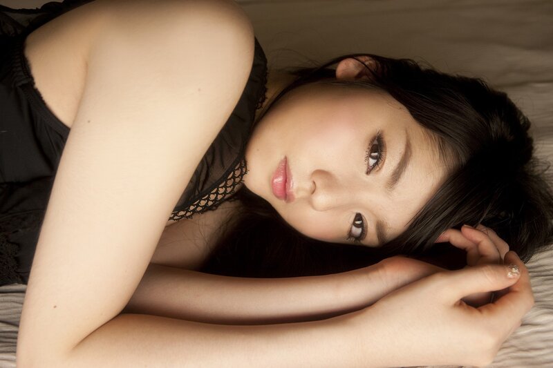 woman lying on bed in black top