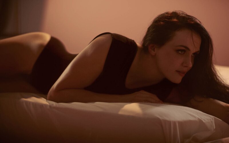 woman lying on bed in dim light