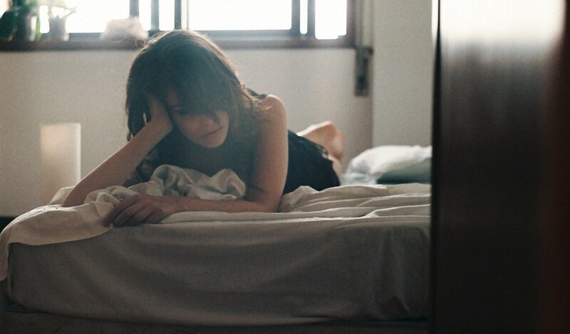 woman lying on bed in morning light