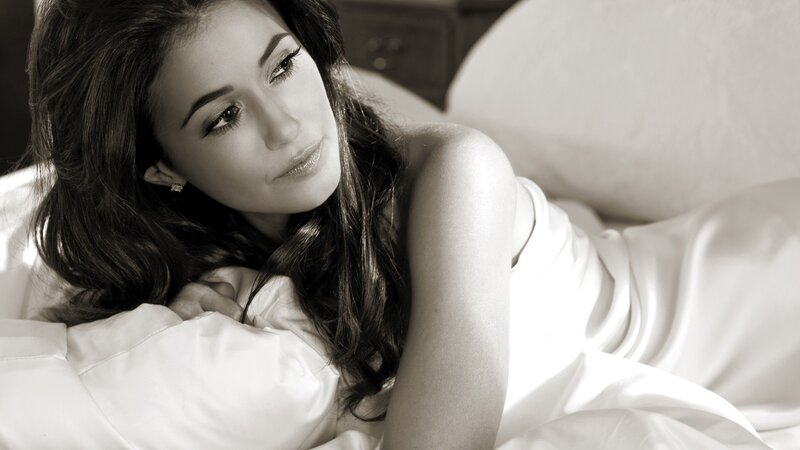 woman lying on bed in sepia