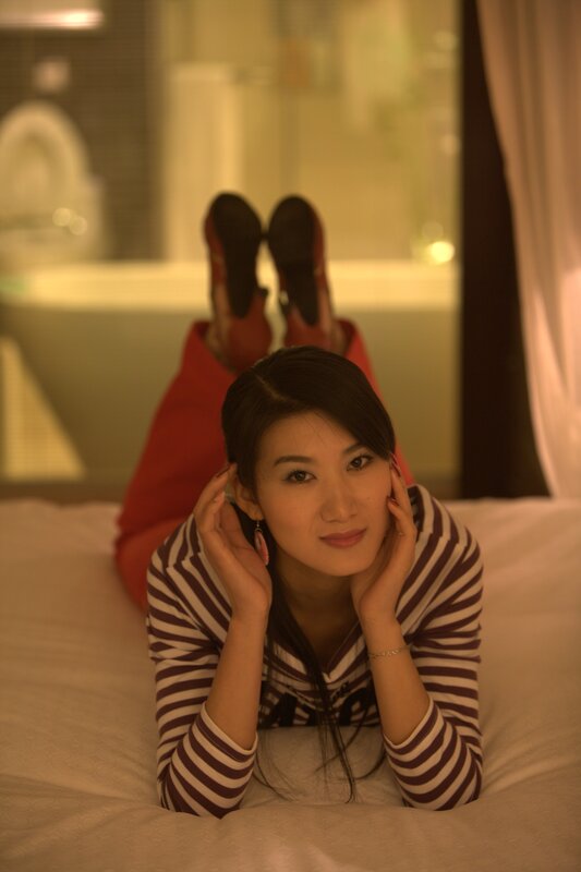woman lying on bed in striped shirt