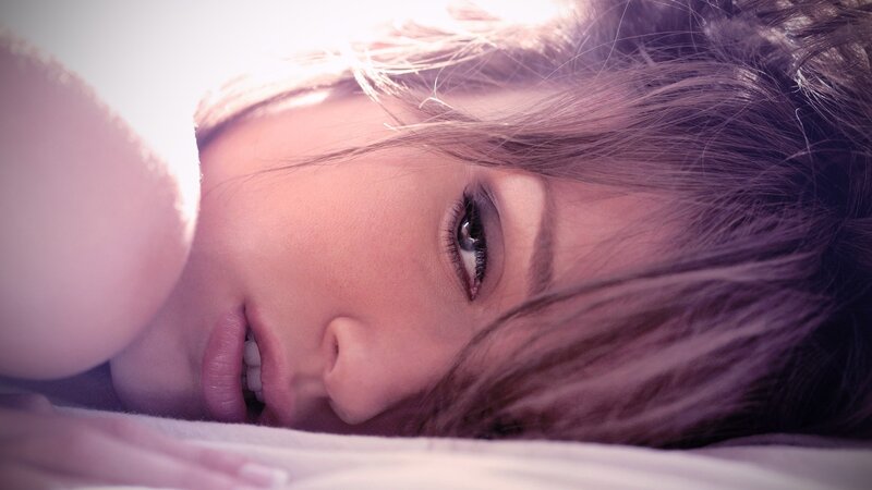 woman lying on bed in sunlight