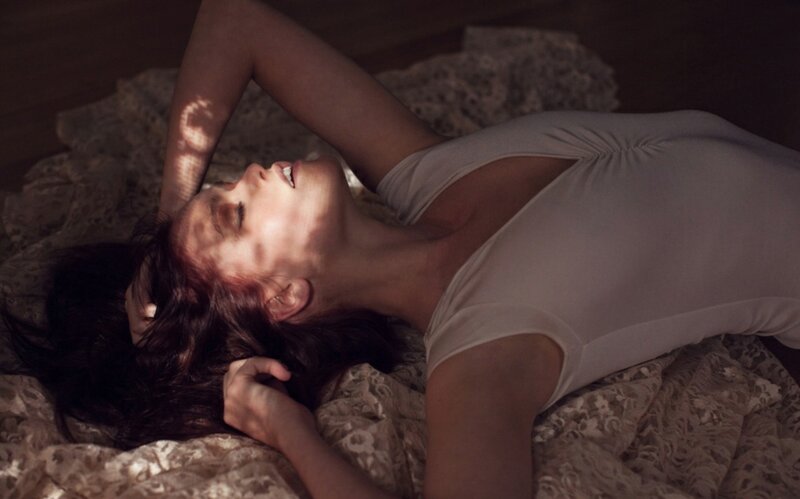 woman lying on bed in sunlight