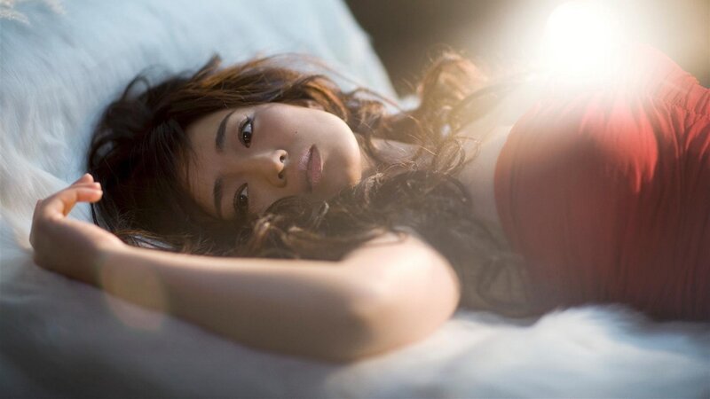 woman lying on bed in sunlight