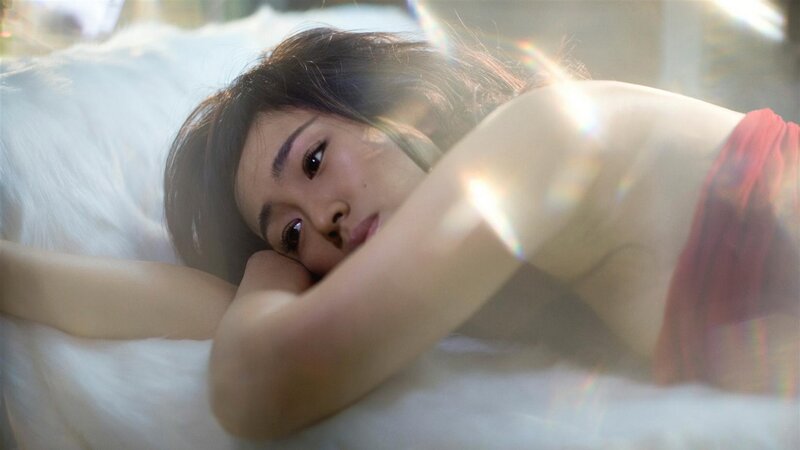 woman lying on bed in sunlight