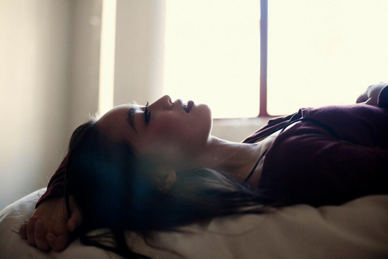 woman lying on bed in sunlight