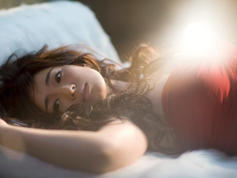 woman lying on bed in sunlight