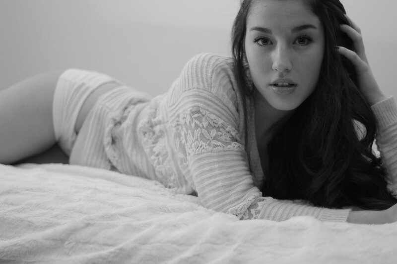 woman lying on bed in sweater