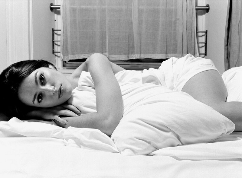 woman lying on bed in white