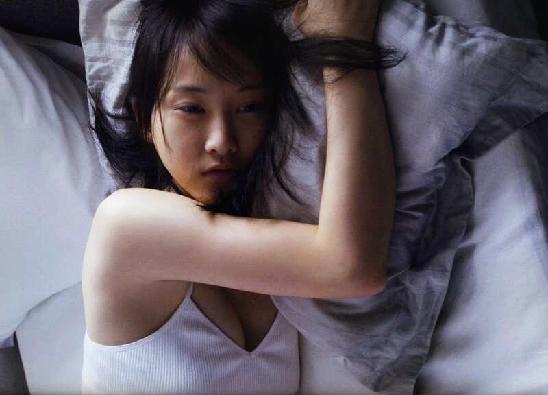 woman lying on bed in white top