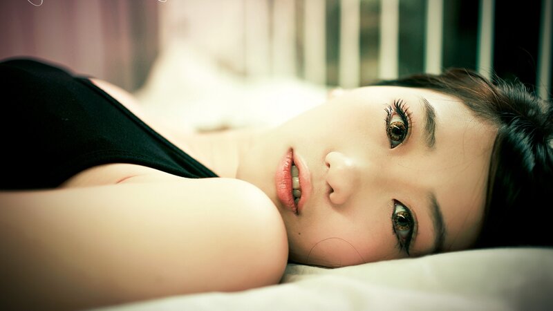 woman lying on bed looking at camera