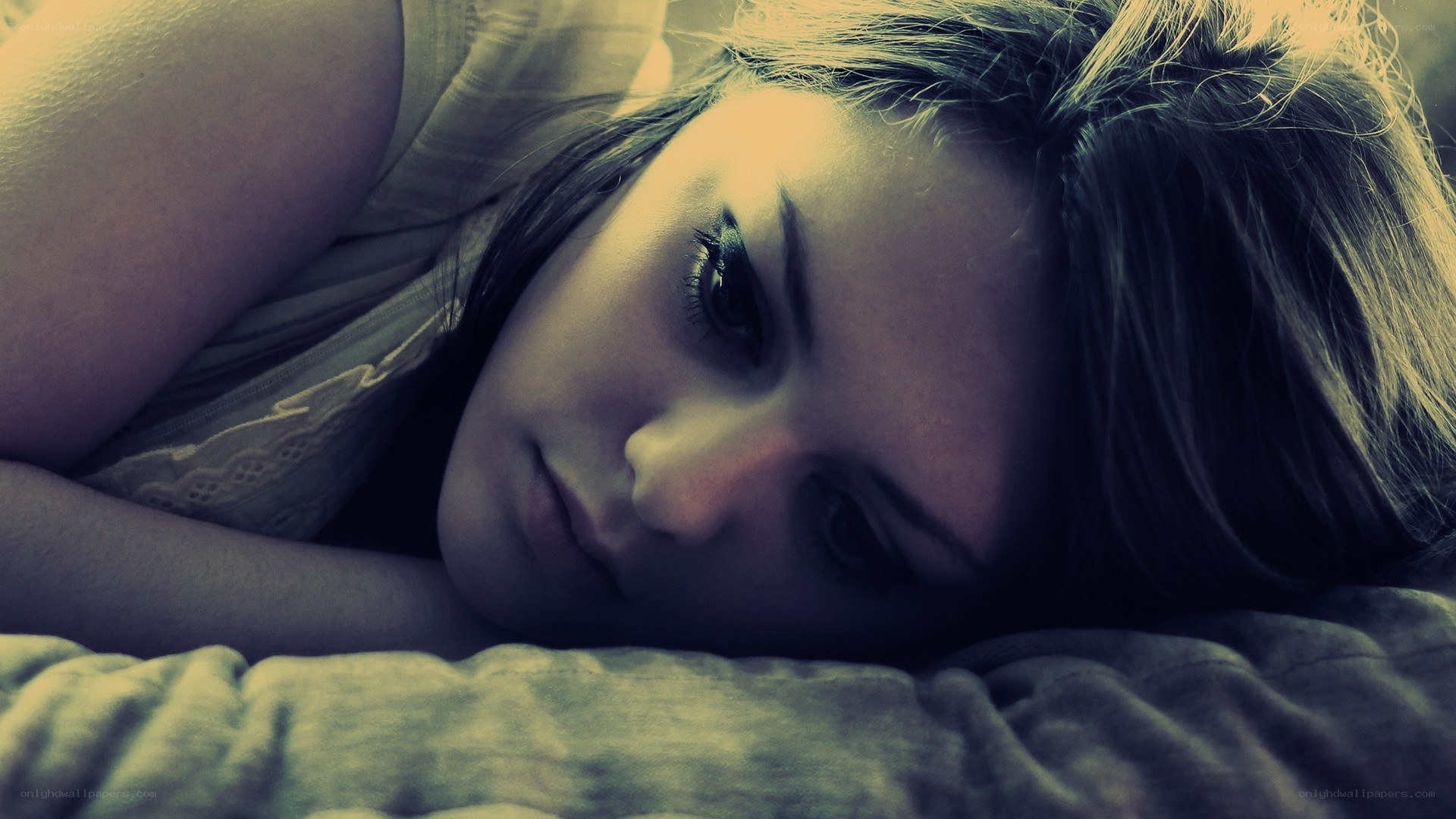 woman lying on bed looking down