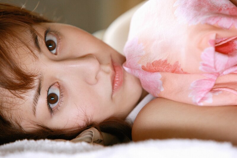 woman lying on bed with blanket