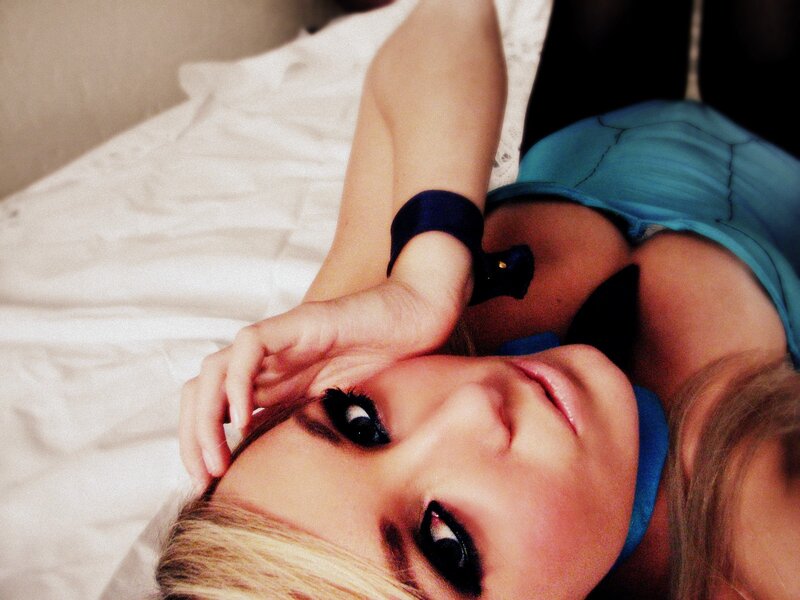 woman lying on bed with hand on face
