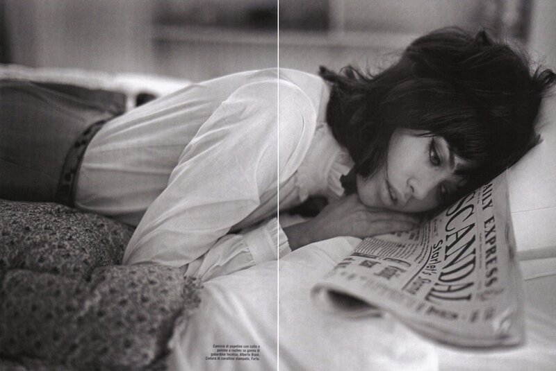 woman lying on bed with newspaper