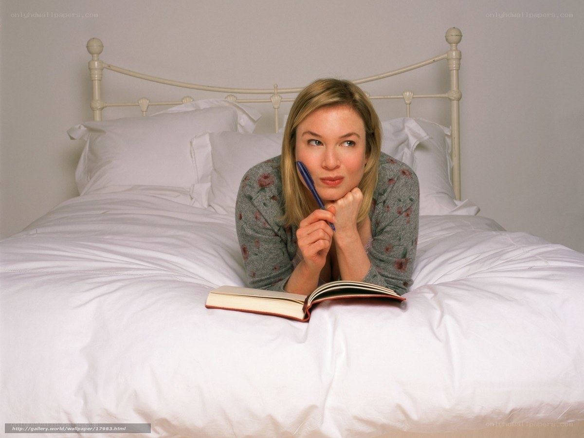 woman lying on bed with notebook
