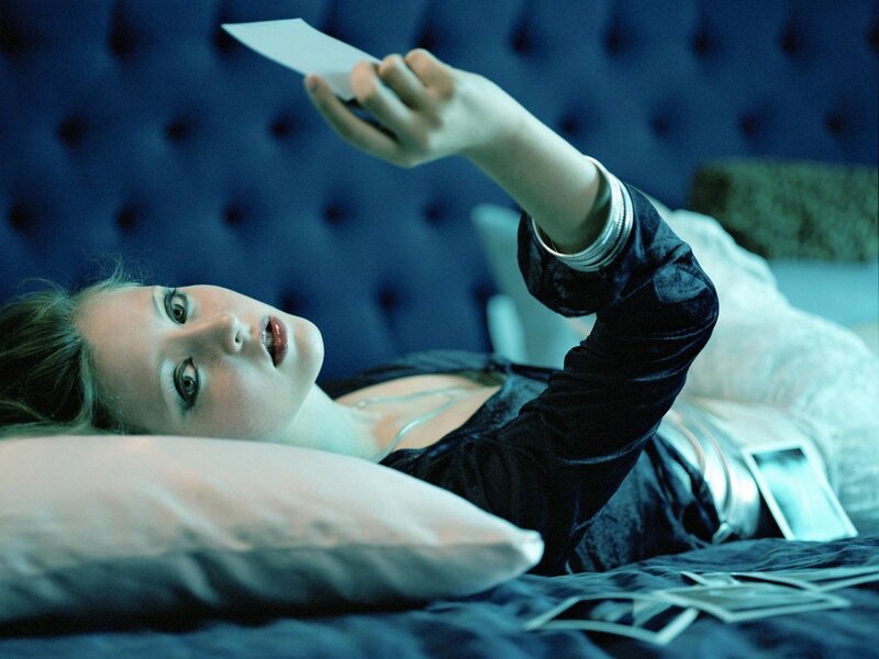 woman lying on bed with photo