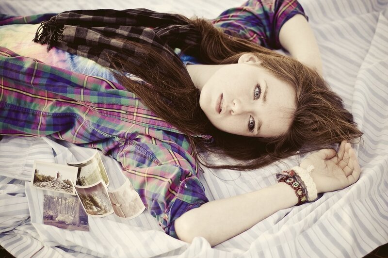 woman lying on bed with photos