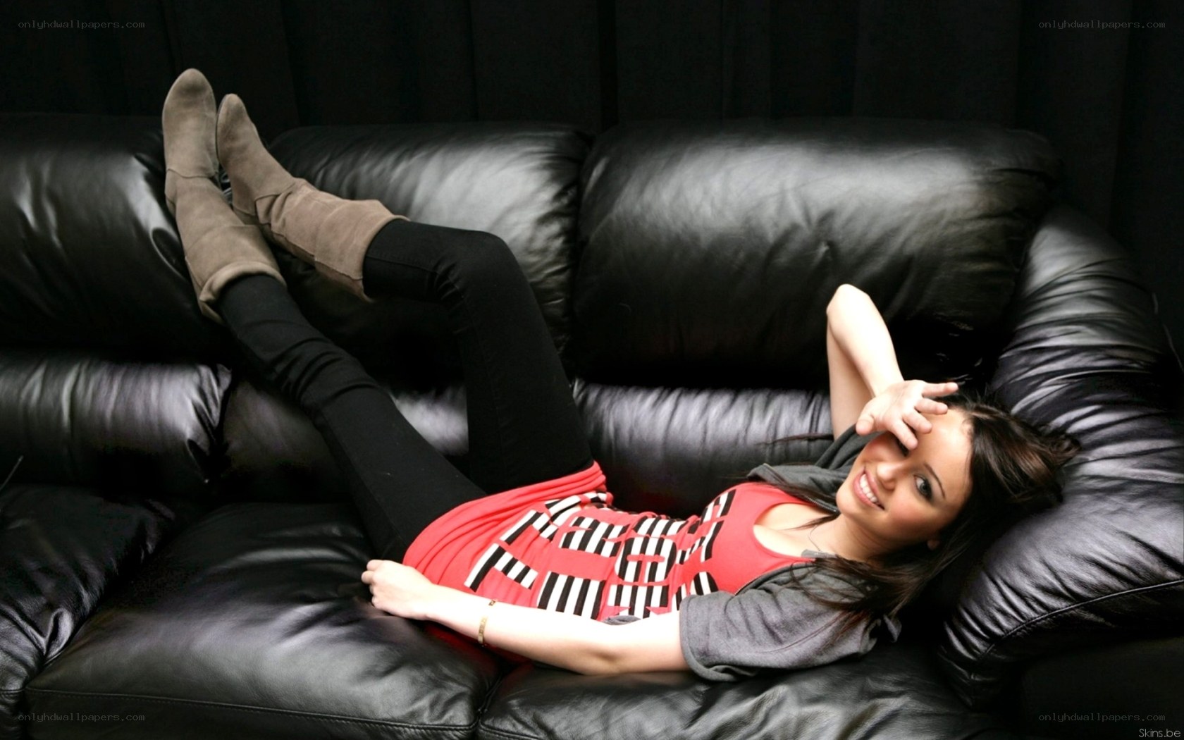 woman lying on black couch