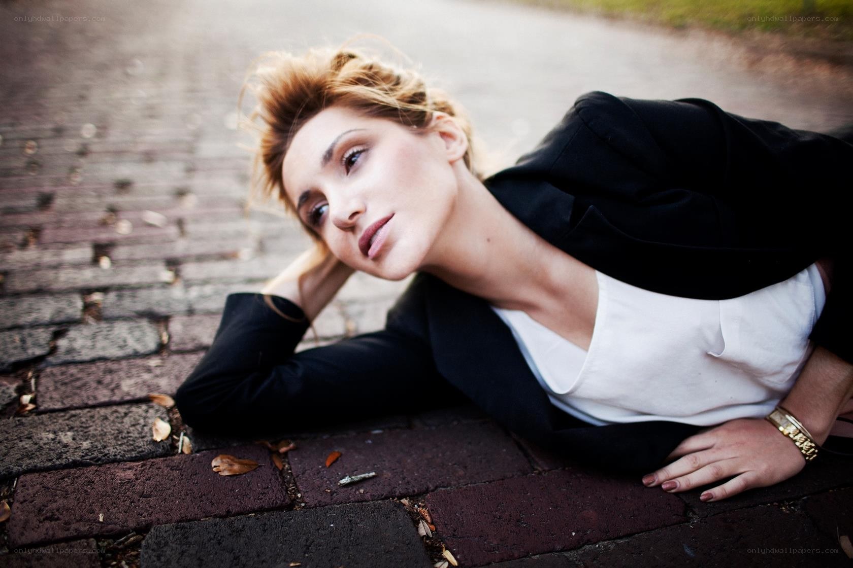 woman lying on brick pavement