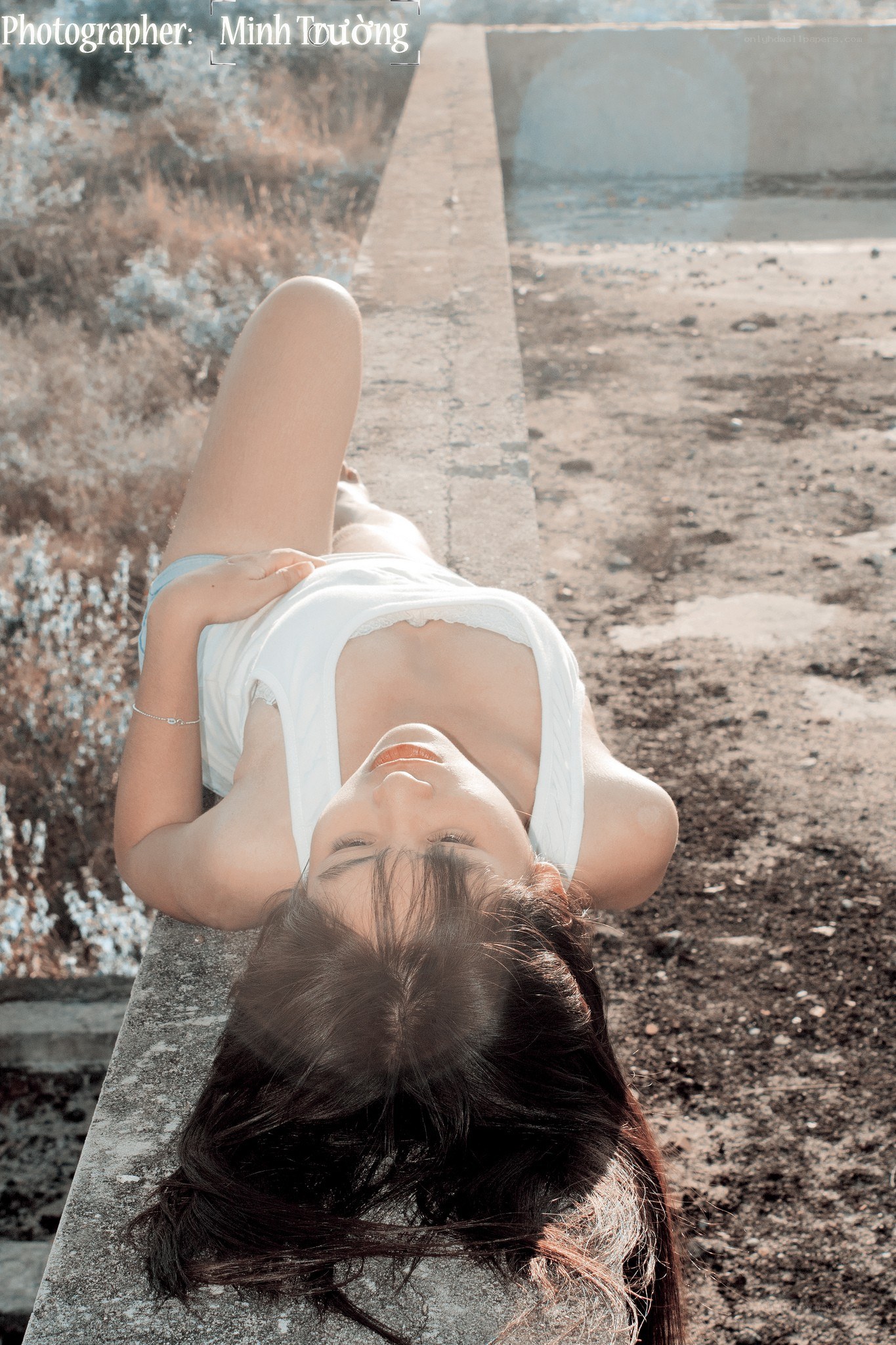 woman lying on concrete ledge