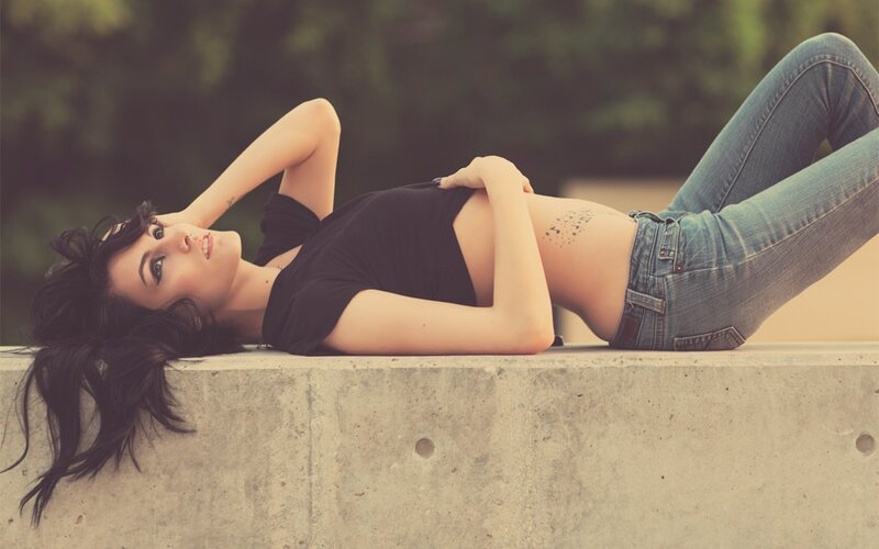 woman lying on concrete ledge