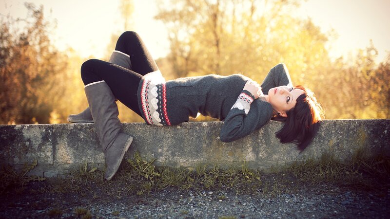 Woman lying on concrete wall