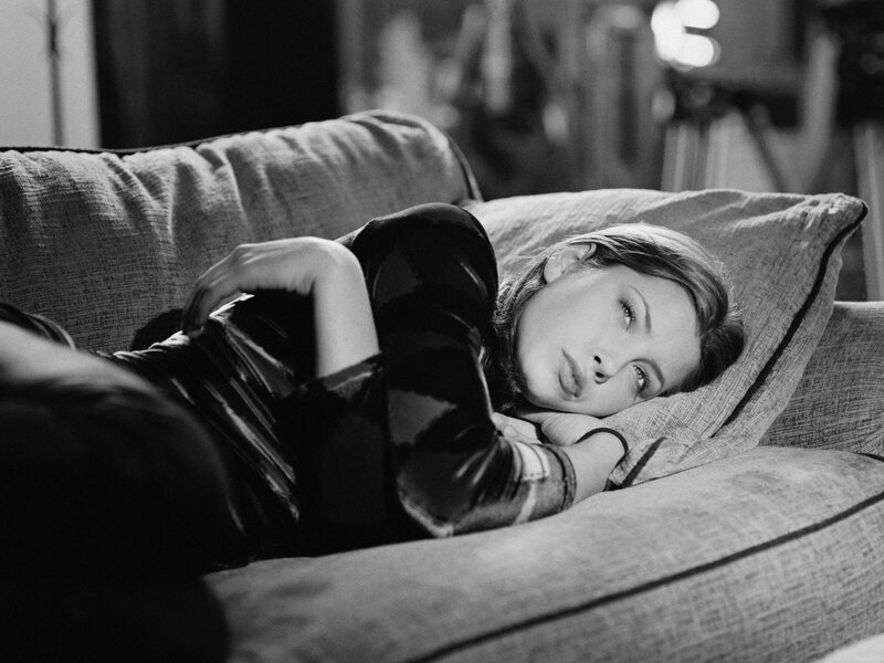 Woman Lying on Couch — Black, Contemplative, Photograph, Pillow, Camera, White