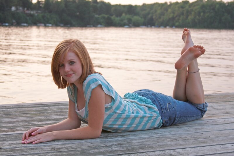 woman lying on dock by lake