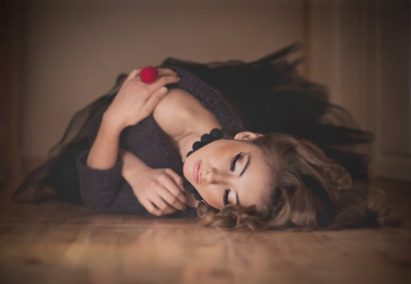 woman lying on floor with red ball
