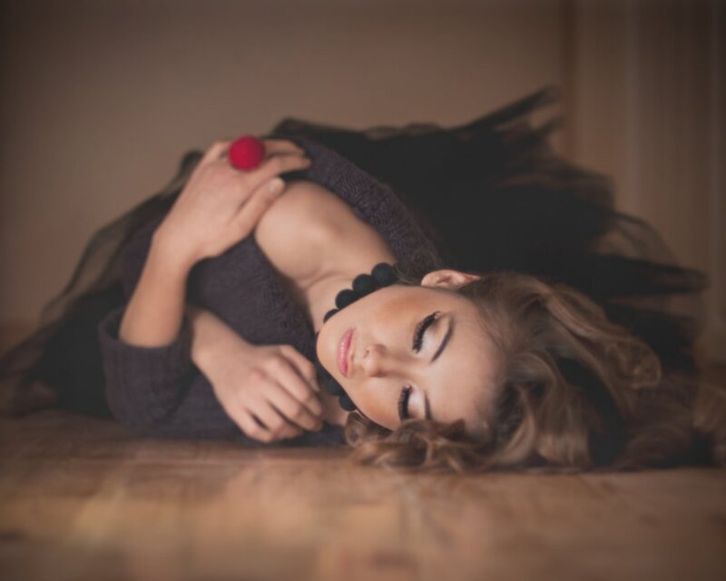 woman lying on floor with red ball