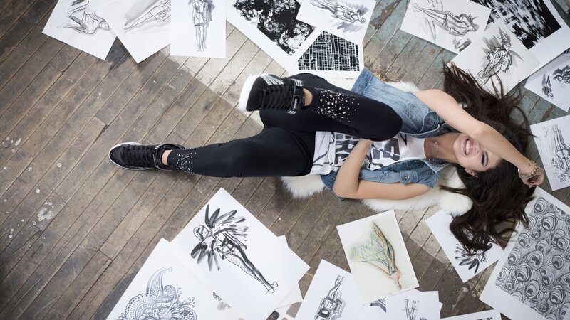 woman lying on floor with sketches