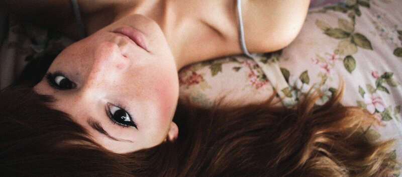 woman lying on floral pillow