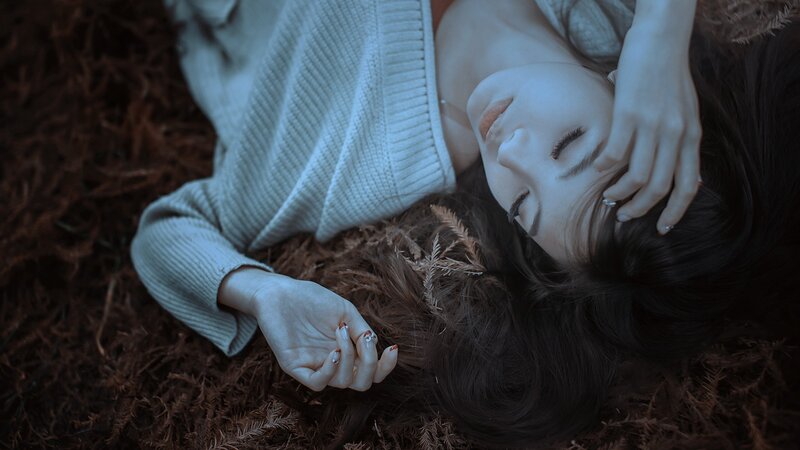 woman lying on forest floor