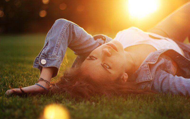 woman lying on grass at sunset