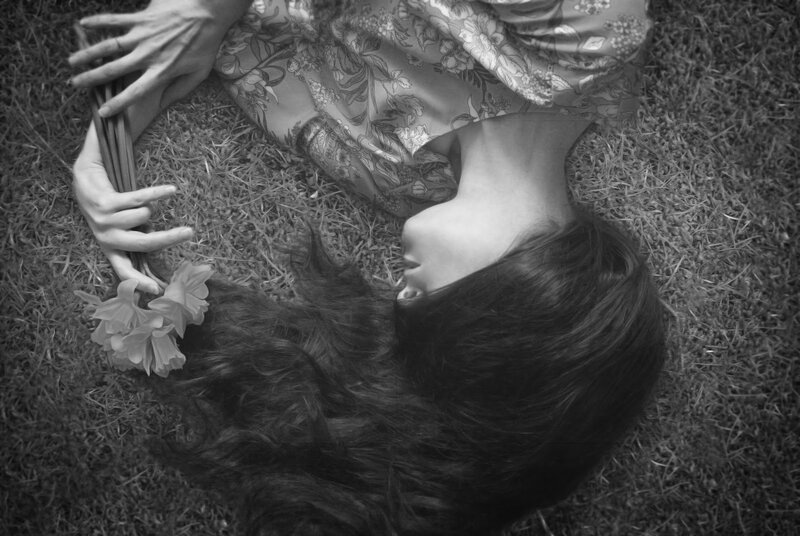 Woman Lying on Grass — Black, Serene, Photograph, Flowers