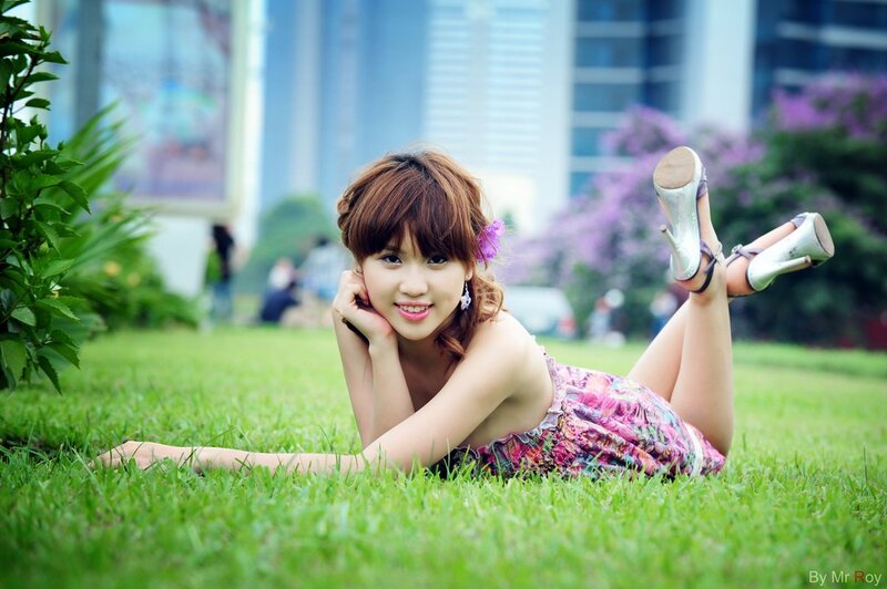 Woman lying on grass in city park