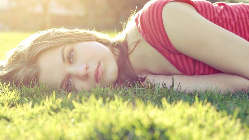 woman lying on grass in sunlight
