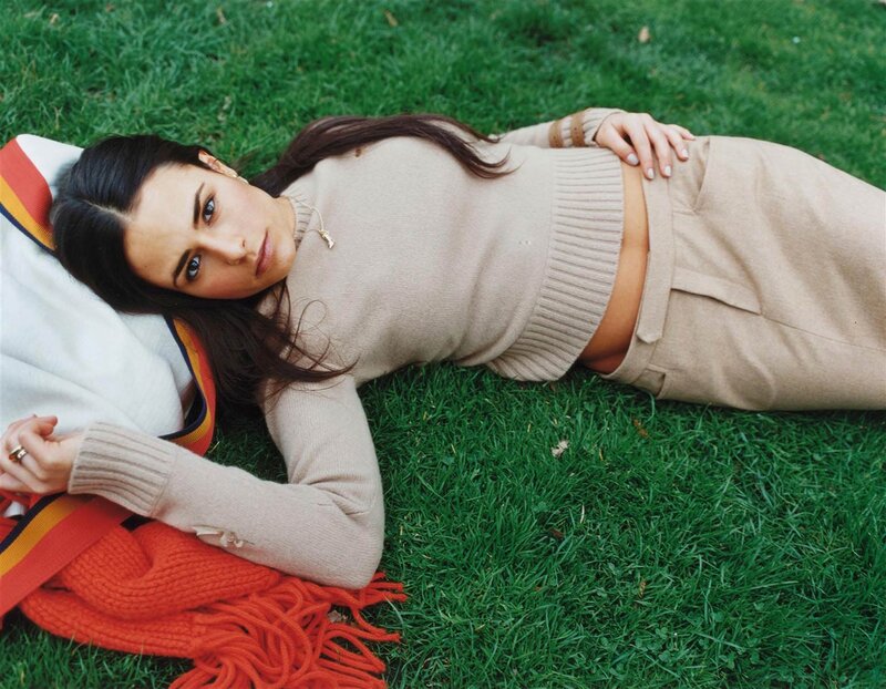 Woman lying on grass in sweater