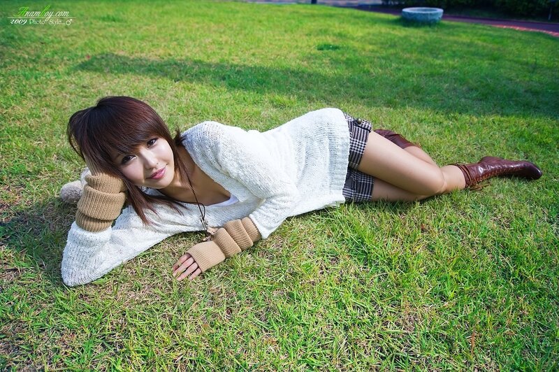 Woman lying on grass in sweater